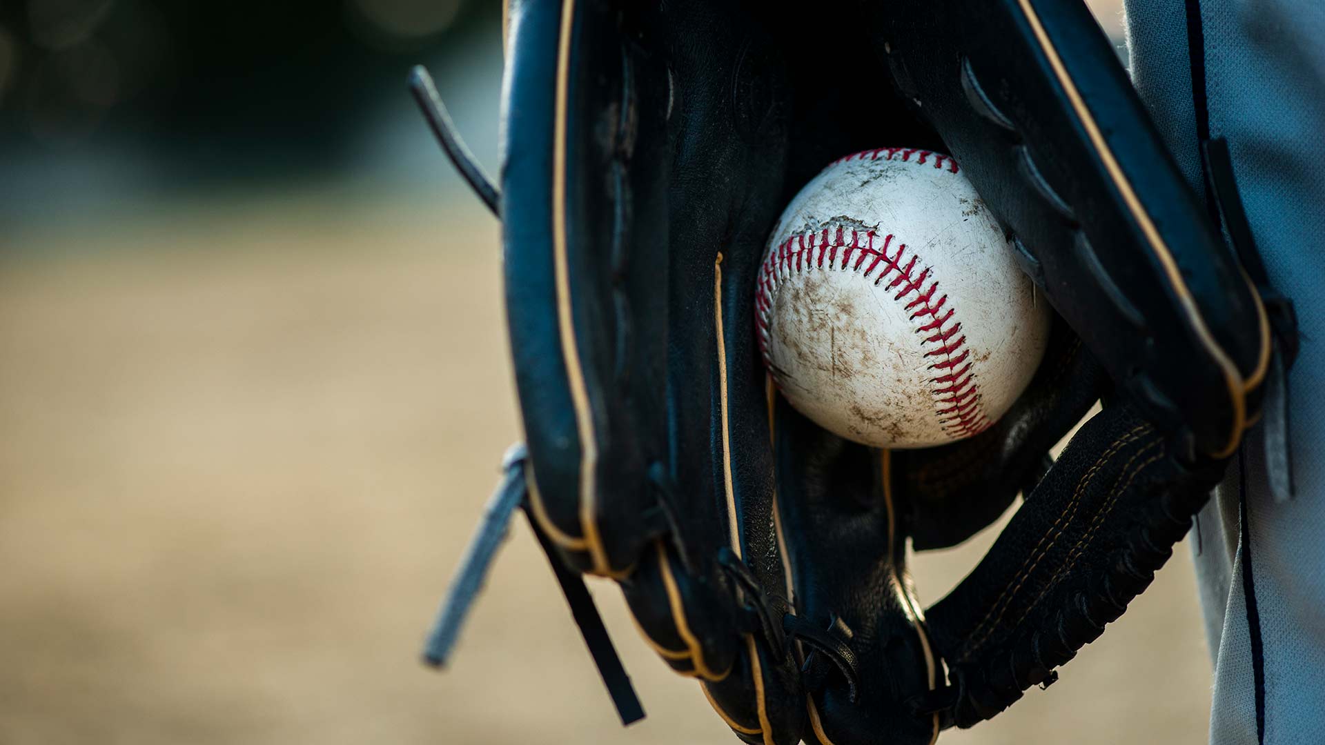close up of baseball held in glove