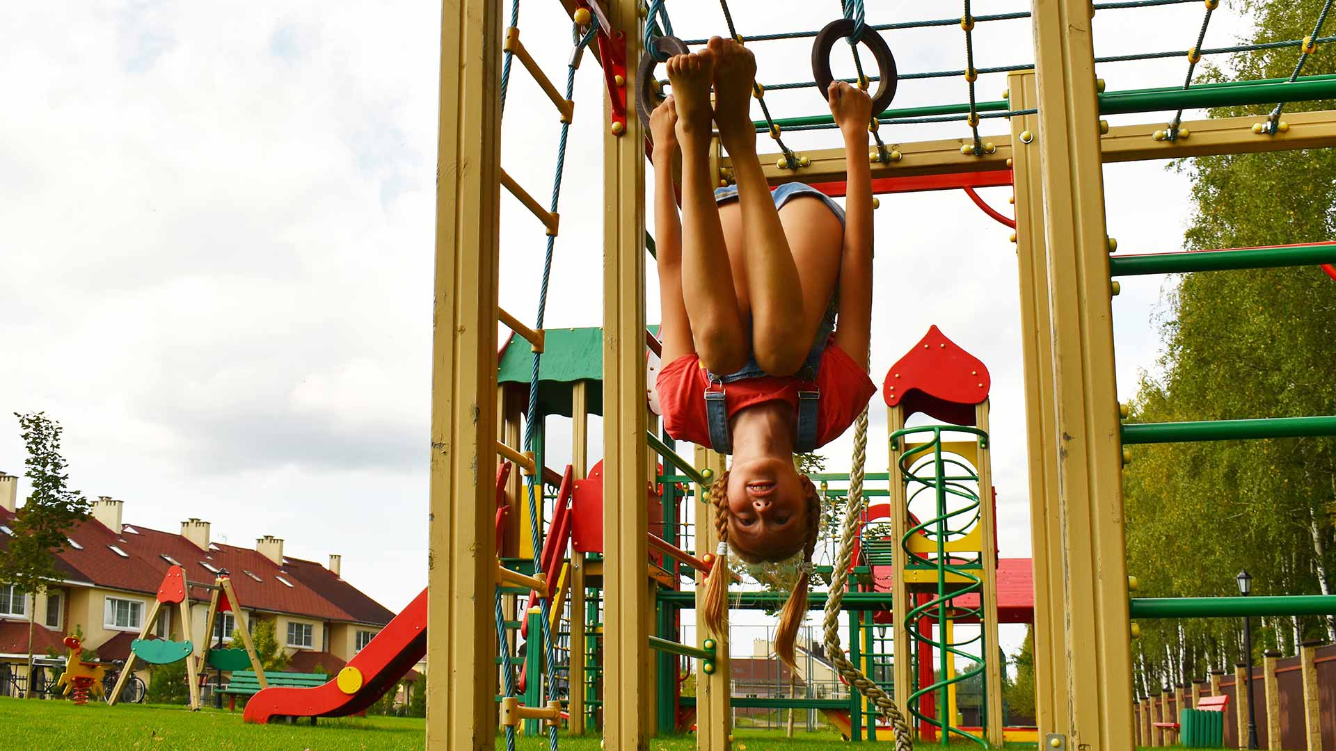 Girl hanging upside down on the playground