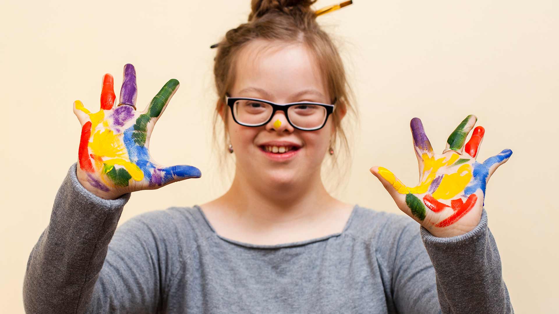 girl with down syndrome showing off her colorful palms
