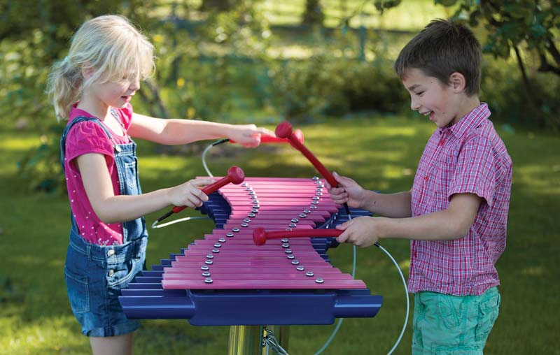 Kids playing on musical playground equipment Kids playing on musical playground equipment
