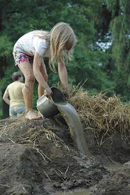 Girl pouring water out of a bucket Girl pouring water out of a bucket