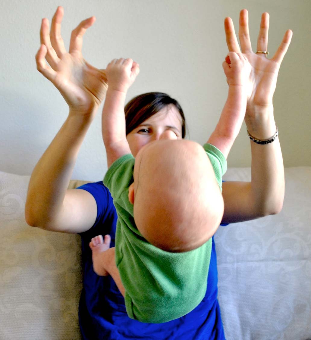 Baby hanging from mother's thumbs Baby hanging from mother's thumbs
