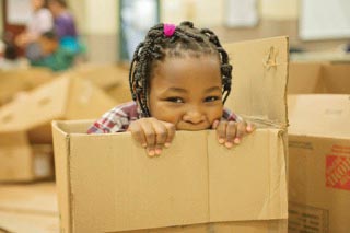 Girl playing in cardboard box Girl playing in cardboard box