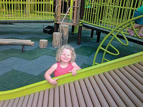 child standing near roller slide