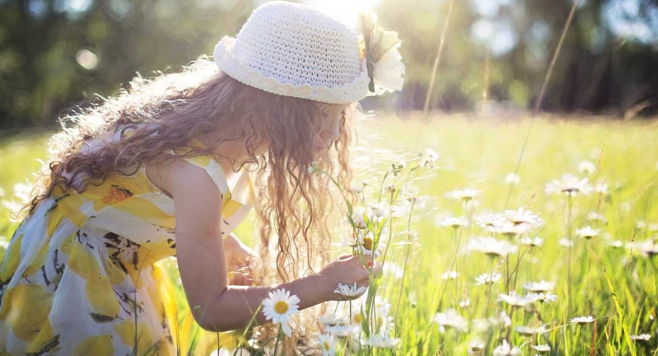 young girl playing in field of grass