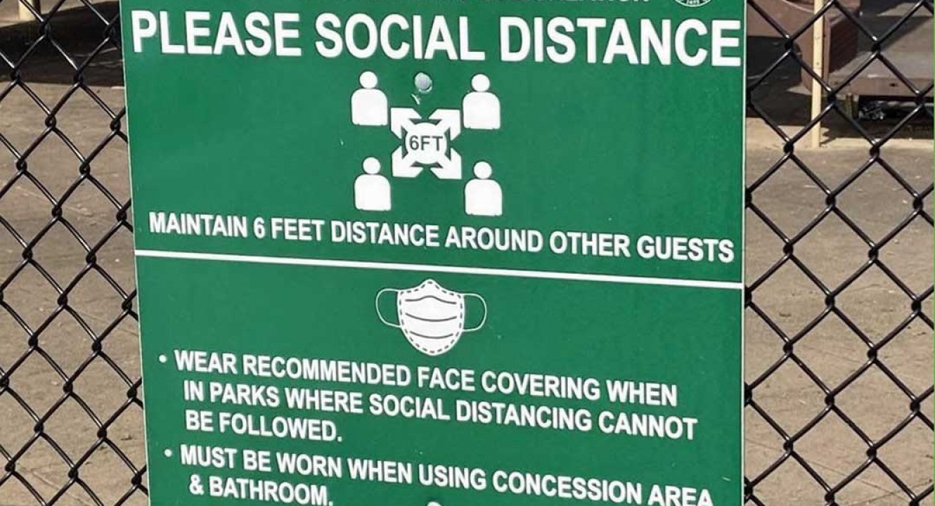 sign recommending social distancing and mask wearing