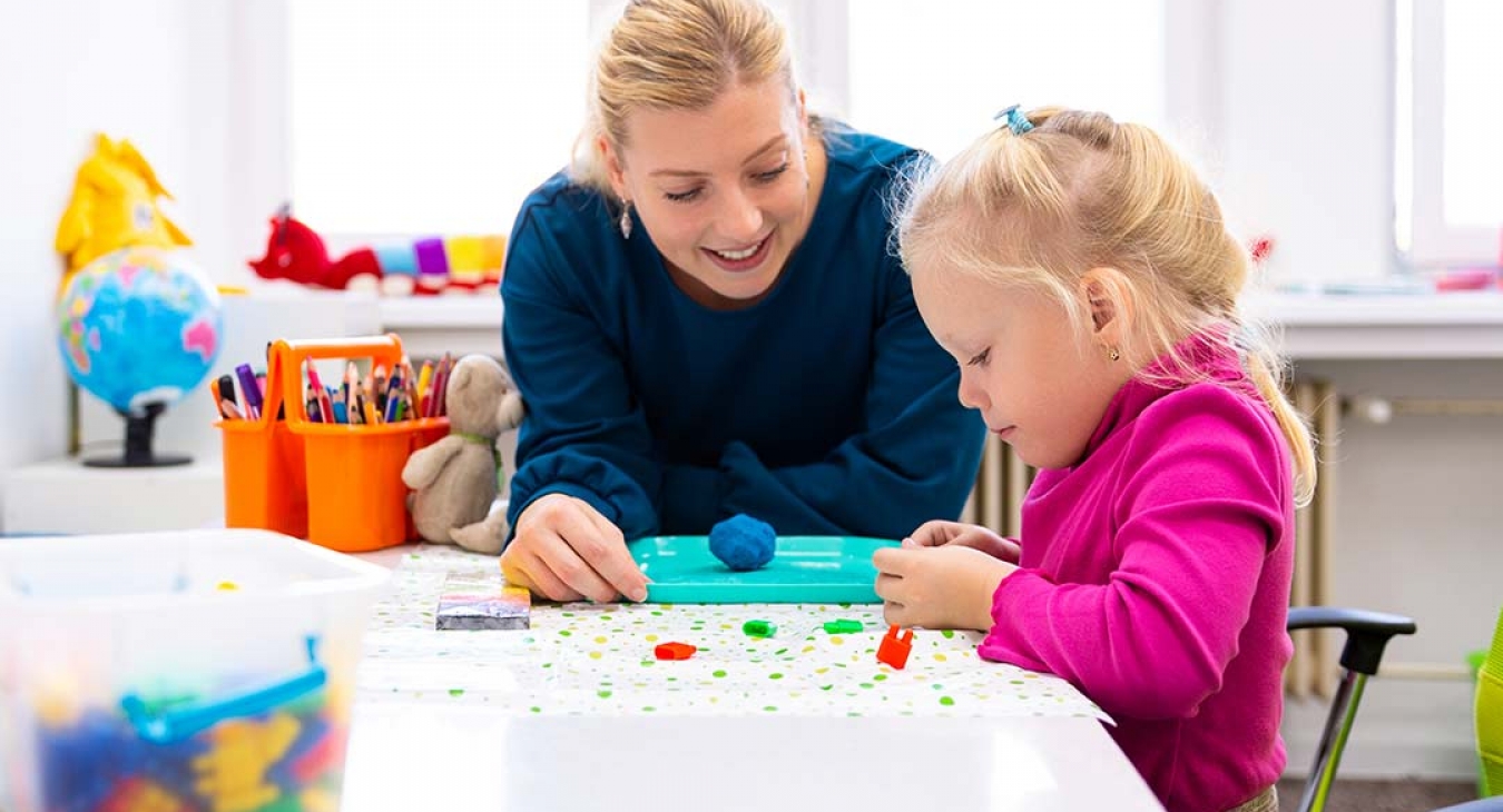 Therapist using games and play to help little blonde girl