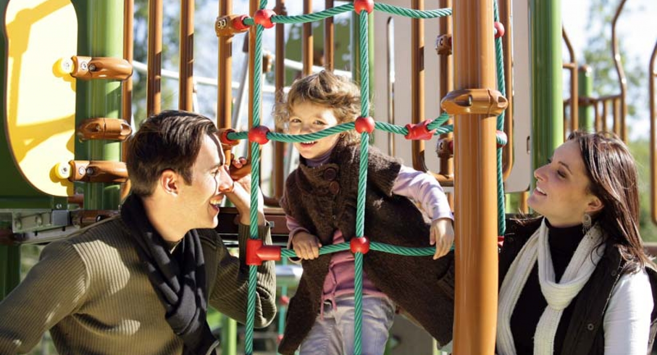 Parents playing with child on playground