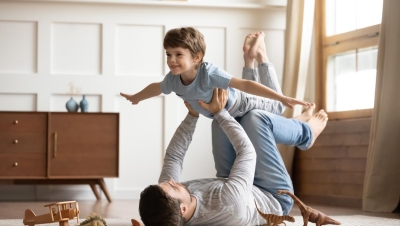 Dad playing airplane with son