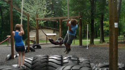 Teens playing on a playground made from old tires.